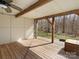 A covered porch with wooden beams and a view of the woods at 14723 Sapphire Ln, Pineville, NC 28134