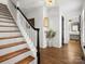 Inviting foyer with a traditional staircase featuring hardwood treads and a black and white banister at 14723 Sapphire Ln, Pineville, NC 28134