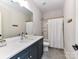 Bathroom featuring a single sink vanity with dark cabinets and shower/tub combo at 15140 Rocky Bluff Loop, Davidson, NC 28036