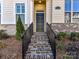 Inviting front entrance with brick steps and wrought iron railing to the black front door at 15140 Rocky Bluff Loop, Davidson, NC 28036