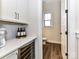Chic butler's pantry with white cabinets, wine cooler, quartz counters and lovely wine storage at 15140 Rocky Bluff Loop, Davidson, NC 28036