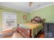 Comfortable bedroom with a queen-size bed, hardwood floors, and large window overlooking the front yard at 1740 12Th Street Nw Dr, Hickory, NC 28601