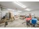A cluttered garage with fluorescent lighting, storage, and a garage door at 1740 12Th Street Nw Dr, Hickory, NC 28601