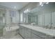 Bathroom featuring a double vanity, soaking tub, glass-enclosed shower, and neutral tile at 17609 Caddy Ct, Charlotte, NC 28278