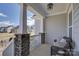 Cozy front porch seating area with wicker chair and stone accents, offering a relaxing outdoor space at 17609 Caddy Ct, Charlotte, NC 28278