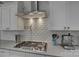 Close-up of kitchen features including white cabinets, subway tile backsplash, and gas stovetop at 17609 Caddy Ct, Charlotte, NC 28278