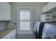 Functional laundry room with modern appliances, white cabinets, shelving, and natural light at 17609 Caddy Ct, Charlotte, NC 28278