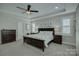 Well-lit main bedroom featuring a dark wood bed set, neutral walls, and windows with privacy blinds at 17609 Caddy Ct, Charlotte, NC 28278