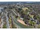 Aerial view of townhomes beside a creek with a community pool and a sandy beach at 19827 Henderson Rd # L, Cornelius, NC 28031