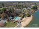 Aerial view showcasing a community pool, lake access, sandy beach, and beautiful homes at 19827 Henderson Rd # L, Cornelius, NC 28031