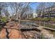 Scenic waterfront view featuring a wooden boardwalk, lake and pedestrian bridge, lined with mature trees at 19827 Henderson Rd # L, Cornelius, NC 28031