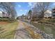 Waterfront view featuring a canal with a walkway, lush grass, and neighboring condos creating a cozy community at 19827 Henderson Rd # L, Cornelius, NC 28031