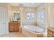 Elegant bathroom featuring soaking tub, granite countertop, and natural light at 208 Woodwinds Dr, Mount Holly, NC 28120