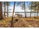 Wooden dock leading to a lake, lined by mature trees with a covered gazebo and open water at 208 Woodwinds Dr, Mount Holly, NC 28120