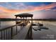 Picturesque dock with covered seating area extending into calm water at 208 Woodwinds Dr, Mount Holly, NC 28120