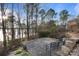 Brick patio area with seating, surrounded by landscaping and mature trees near the water at 208 Woodwinds Dr, Mount Holly, NC 28120