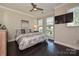Bright bedroom featuring a gray accent wall, a ceiling fan, and plenty of natural light from large windows at 231 Uptown West Dr, Charlotte, NC 28208