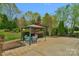 Landscaped backyard featuring a shaded seating area and lush green lawn at 2711 Liberty Hall Ct, Waxhaw, NC 28173