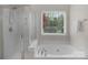 Bright bathroom with a soaking tub, separate shower, and large window with a view of the backyard at 2711 Liberty Hall Ct, Waxhaw, NC 28173