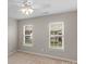 Bright bedroom with plush carpet, ceiling fan, and two windows, perfect for a good night's sleep at 2711 Liberty Hall Ct, Waxhaw, NC 28173