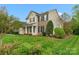 Charming two-story home featuring manicured lawn, neutral siding and brick accents with black shutters at 2711 Liberty Hall Ct, Waxhaw, NC 28173