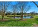 Scenic community pond with fountain and well-maintained grassy banks, perfect for relaxation at 2711 Liberty Hall Ct, Waxhaw, NC 28173