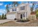 Two-story home with a well-manicured lawn, two-car garage, and updated landscaping at the front entrance at 2729 Yurman Rd, Charlotte, NC 28214