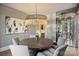 Stylish dining room with designer light fixture, table setting and views of the wine cellar at 4018 St Germaine Ln, Charlotte, NC 28210