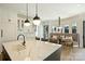 A modern kitchen island with white marble countertops, pendant lighting, and an adjacent dining nook at 4018 St Germaine Ln, Charlotte, NC 28210