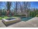 Backyard pool and hot tub with a playset in the background at 4018 St Germaine Ln, Charlotte, NC 28210