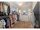 Spacious walk-in closet with custom shelving, mirrored cabinets, and abundant natural light at 4018 St Germaine Ln, Charlotte, NC 28210