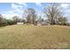 Grassy backyard with a large house in the background and mature trees on a bright, sunny day at 422 Lee Ave, Wadesboro, NC 28170