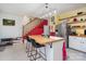 Unique kitchen boasts a butcher block island with sink, stainless fridge, and bright yellow and red accents at 422 Lee Ave, Wadesboro, NC 28170