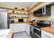 Well-organized kitchen features stainless steel appliances, wood countertops, and open shelving for storage at 422 Lee Ave, Wadesboro, NC 28170