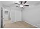 Second bedroom with neutral carpet, ceiling fan, and walk-in closet at 4264 Glenlea Commons E Dr, Charlotte, NC 28216