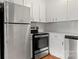 Kitchen featuring stainless steel oven, refrigerator, and white cabinetry at 434 W 8Th St, Charlotte, NC 28202