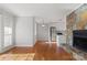Bright living room with hardwood floors, a stone fireplace, and an open view into the kitchen at 434 W 8Th St, Charlotte, NC 28202