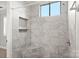 The modern walk-in shower is tiled in marble and features a bench and convenient recessed shelving at 434 W 8Th St, Charlotte, NC 28202