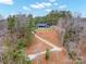 An aerial view of the home surrounded by trees with backyard firepit and covered patio at 4890 Rio De Luna None, Hickory, NC 28601