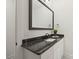 Modern bathroom vanity with sleek dark countertop, white cabinets, and a large framed mirror, offering a clean aesthetic at 4890 Rio De Luna None, Hickory, NC 28601