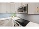 Close-up of a modern kitchen featuring white cabinets, stainless steel appliances, and hexagon backsplash at 4890 Rio De Luna None, Hickory, NC 28601
