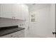 Bright laundry room features sleek white cabinets, gray countertop, and modern fixtures for efficient home management at 4890 Rio De Luna None, Hickory, NC 28601