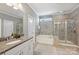 Bright bathroom with granite countertops, a separate tub, and a tiled shower at 503 Dixter Ln, Charlotte, NC 28211