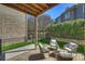 Covered outdoor patio featuring brick pavers, comfortable seating, and a view of the backyard at 503 Dixter Ln, Charlotte, NC 28211