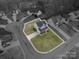 An aerial view of a charming two-story house with a well-manicured lawn and a spacious driveway at 5032 Meadow Woods Dr, Lowell, NC 28098
