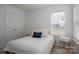 Bright bedroom features a large window, closet, and a cozy bed with accent pillows at 5032 Meadow Woods Dr, Lowell, NC 28098