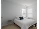 Bright bedroom features two windows, neutral walls, and a cozy bed with accent pillows at 5032 Meadow Woods Dr, Lowell, NC 28098