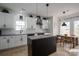 Modern kitchen featuring white cabinets, a dark island, granite countertops, and stainless steel appliances at 5032 Meadow Woods Dr, Lowell, NC 28098