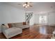 Bright living room featuring hardwood floors, a comfortable sectional sofa, and large windows providing ample natural light at 5032 Meadow Woods Dr, Lowell, NC 28098
