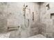 Updated shower featuring stone-look tile, built-in shower seat, and bronze fixtures at 5101 Gamton Ct, Charlotte, NC 28226
